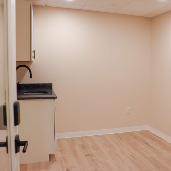 A Foundation Studio at Riviera Salon Studios that is equipped with spacious cabinetry, a granite countertop, and a wash sink.