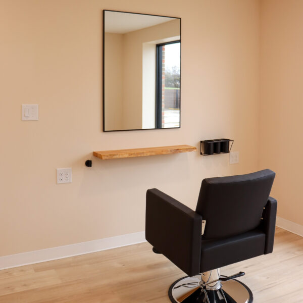 A Premier Studio at Riviera Salon Studios that is warm and welcoming with a large window that lets in natural light.